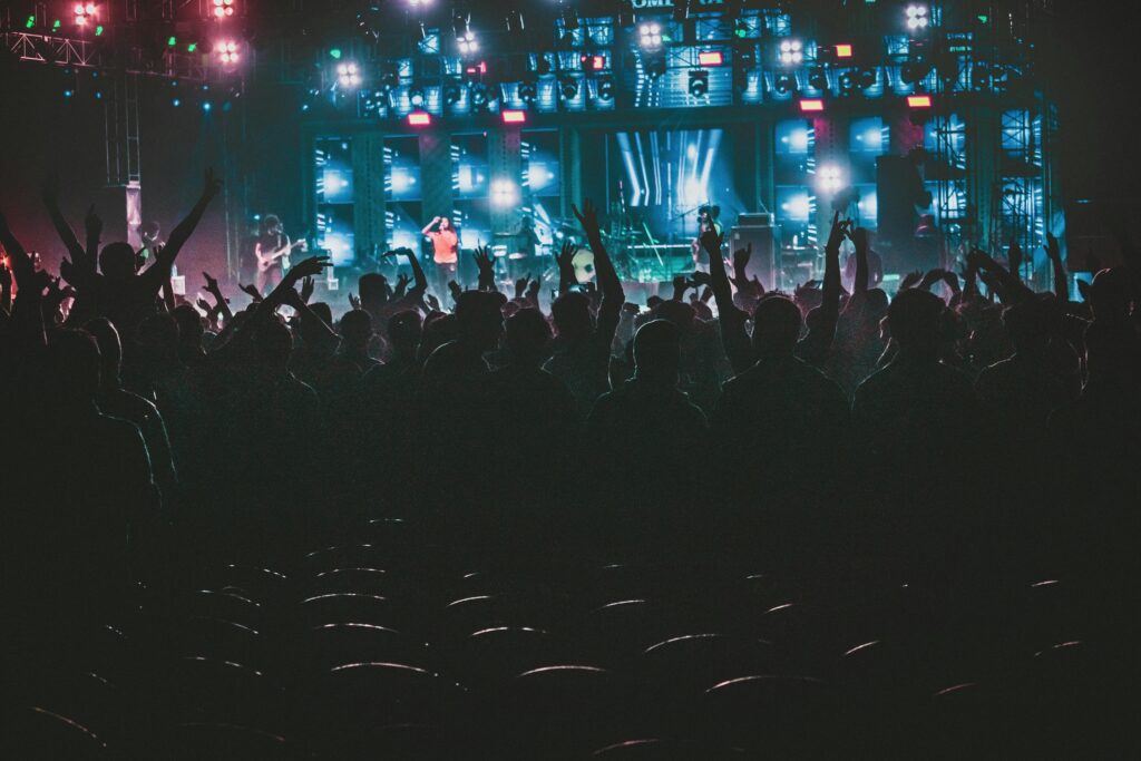 Energetic crowd enjoying a live music concert with colorful lights in Contai, West Bengal, India.